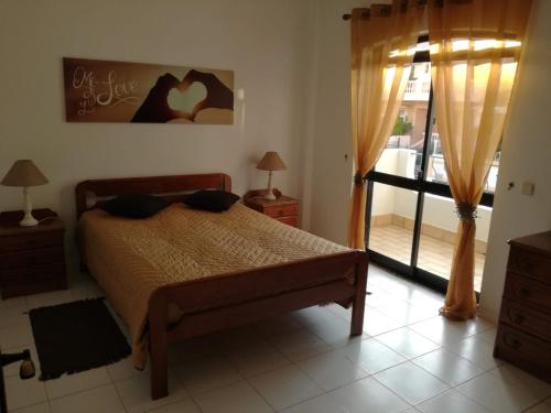 a bedroom with a bed and a door to a balcony at Vivenda Bemposta in Alvor