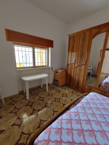 - une chambre avec un lit, une table et une fenêtre dans l'établissement Ferienhaus am Ionischem Meer, à Marina di Lizzano
