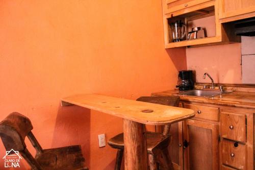 a wooden table in the corner of a kitchen at Cabañas Claro de Luna in Creel