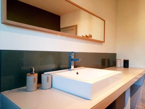 une salle de bain avec un lavabo blanc et un miroir dans l'établissement La Villa l Orangerie, à Vallabrègues