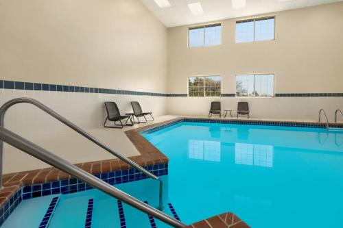 a swimming pool with blue tiles in a building at Baymont by Wyndham Blackwell I-35 in Blackwell