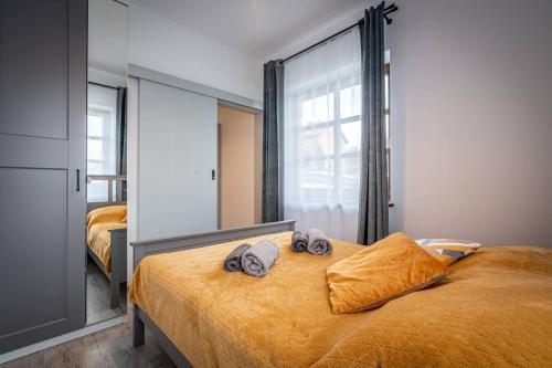 a bedroom with a bed with two towels on it at Apartamenty Ustronne Liściasta in Ustroń