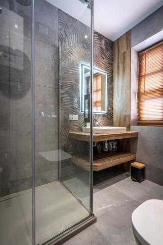a glass shower in a bathroom with a sink at Apartamenty Ustronne Liściasta in Ustroń