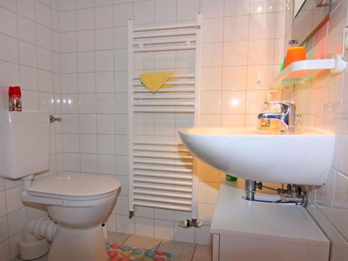 a white bathroom with a sink and a toilet at Appartementhaus Kranichblick in Breege in Breege