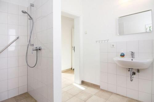 Un baño blanco con ducha y lavabo. en Ferienhaus, Boiensdorf, en Boiensdorf