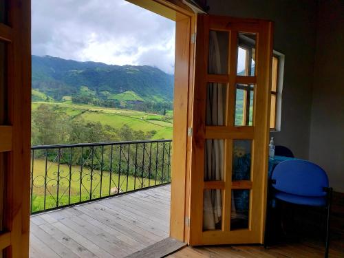 a door to a balcony with a view of a mountain at Hosteria Rose Cottage in Otavalo