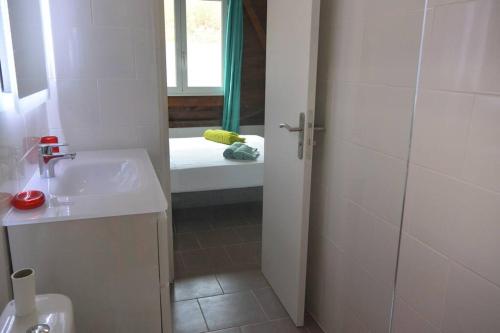 Un baño blanco con lavabo y ducha. en Maison Ste Anne/Marin Piscine personnelle vue sur mer, en Le Marin