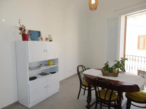 a dining room with a table and a white cabinet at Le Case Di Tufo- Casa del sole in Favignana