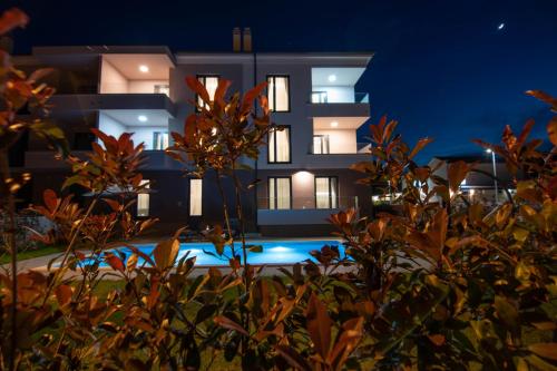 a building with a swimming pool at night at Luxury apartment Grotta with sea view and swimming pool in Premantura