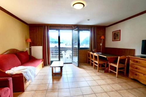 een woonkamer met een rode bank en een tafel bij Apartment Of 55 M With Balcony View Mont Blanc in Chamonix-Mont-Blanc