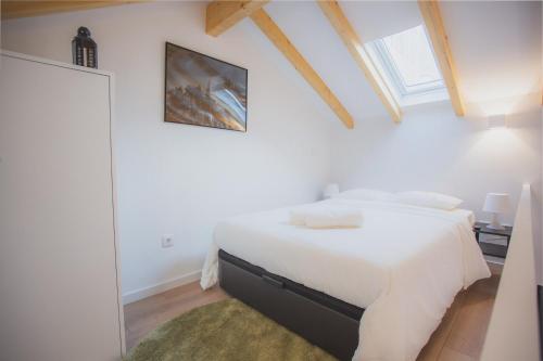 een witte slaapkamer met een bed in een kamer met een raam bij FIVE HOUSE 18 in Porto