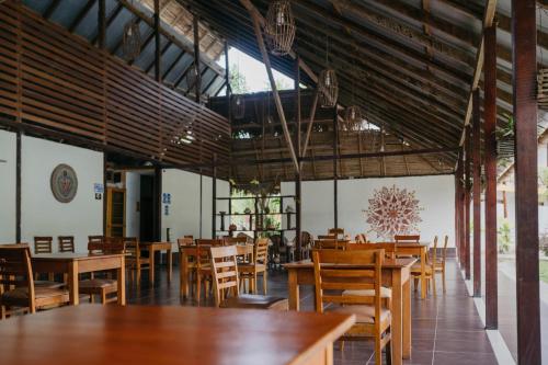Maloca Inn في Sauce: غرفة طعام مع طاولات وكراسي خشبية