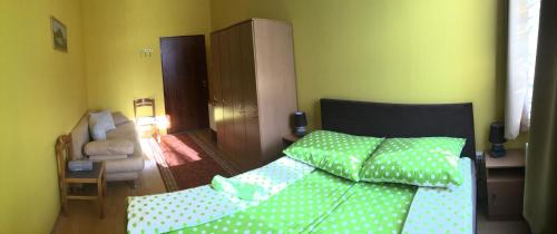 a bedroom with a bed with green polka dot sheets at Örségkapuja Vendégház in Csákánydoroszló