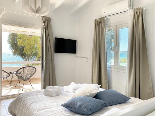 um quarto branco com uma cama e uma varanda em Palm Suite Blue em Porto Heli