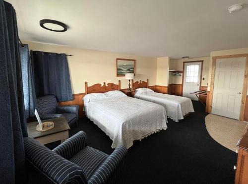 um quarto de hotel com duas camas e um sofá em Moody's Motel and Cottages em Wells