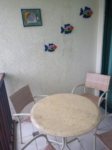 a table and two chairs and a table and some pictures on the wall at Estúdio Marulhos, varanda com vista de mar e parque aquático, à beira-mar de Muro Alto, wi-fi, restaurante, estacionamento e a 10' de Porto de Galinhas in Porto De Galinhas