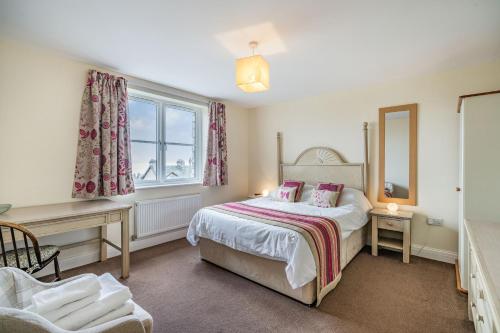 Schlafzimmer mit einem Bett, einem Schreibtisch und einem Fenster in der Unterkunft Hillberry in Grange Over Sands