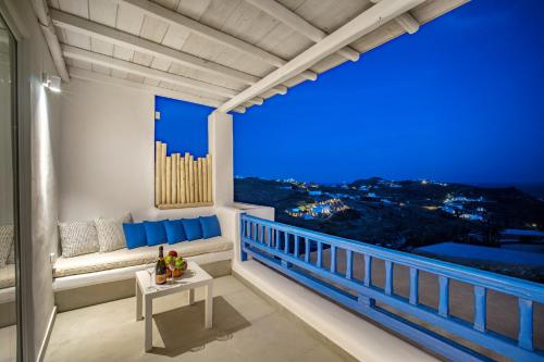 a balcony with a view of the city at night at Anius Apartments in Mýkonos City