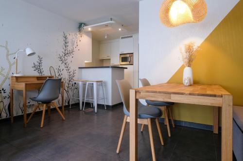 cocina y comedor con mesas y sillas en Location Commodore Oostende, en Ostende
