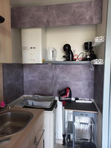 une petite cuisine avec un évier et un comptoir dans l'établissement Appartement T2,33 m2,quartier Malfato et Aqualand, au Cap d'Agde