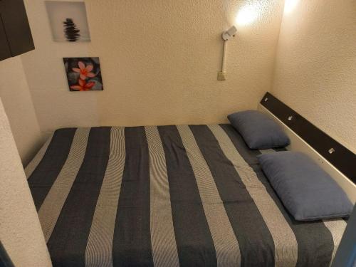 une chambre avec un lit avec deux oreillers dessus dans l'établissement Appartement T2,33 m2,quartier Malfato et Aqualand, au Cap d'Agde