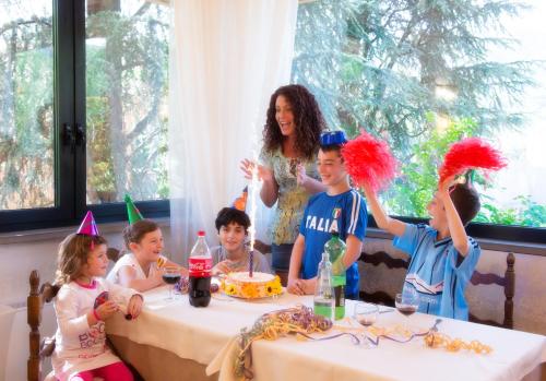 a group of children sitting around a table at a birthday party at EcoHotel Ristorante Milano in Borgo a Mozzano
