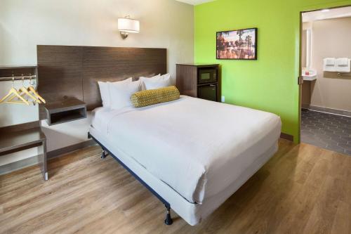 a large bed in a room with a green wall at SureStay Hotel by Best Western San Diego Pacific Beach in San Diego