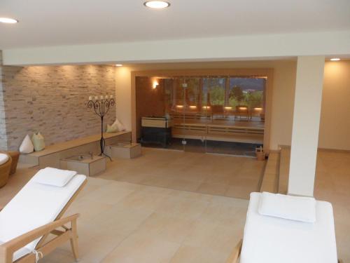 a large room with white furniture and a large window at Nebelhorn Relaxhotel in Obermaiselstein