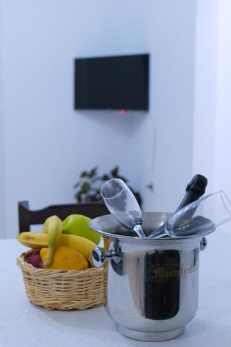 a basket of fruit and utensils sitting on a table at Ernest Apartments in Sarandë