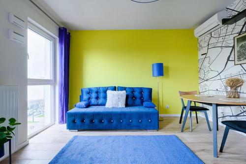 een blauwe bank in een gele kamer met een tafel bij Stylish studio 2 Targowa 10, National Stadium in Warschau