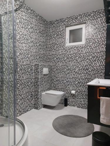 a bathroom with a toilet and a glass shower at Apartman Stella Marina in Šibenik