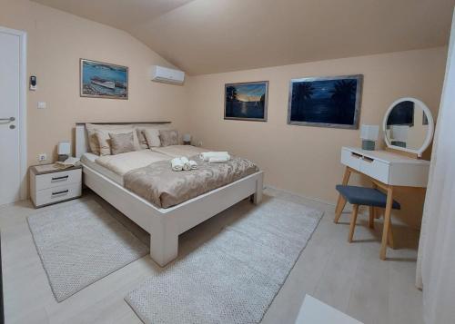 a bedroom with a bed and a sink and a mirror at Apartman Stella Marina in Šibenik
