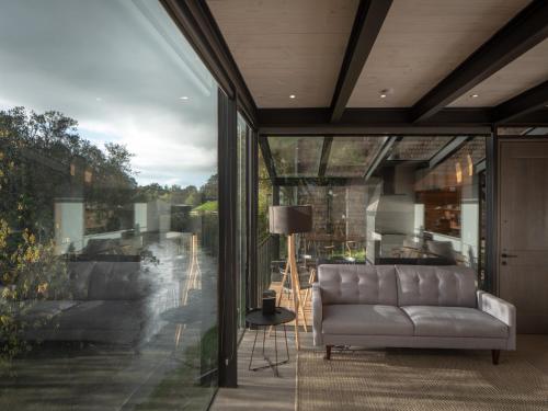 a living room with a couch and a large window at Cabañas Foráneo in Puerto Varas