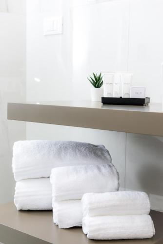 a pile of towels sitting under a shelf at TURINHOMETOWN Residence Apartments in Turin