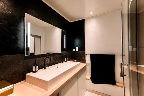 une salle de bain avec un lavabo blanc et un miroir dans l'établissement L’ Appart du Golf, à Saint-Cyprien