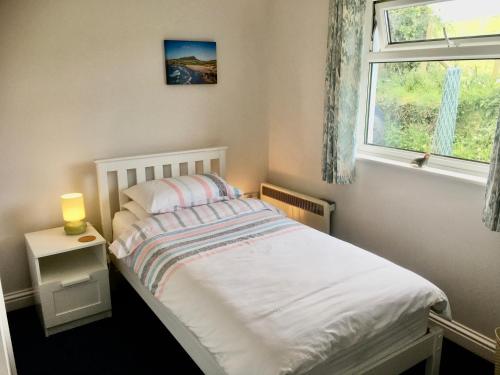 een kleine slaapkamer met een bed en een raam bij Hideaway in Haverfordwest
