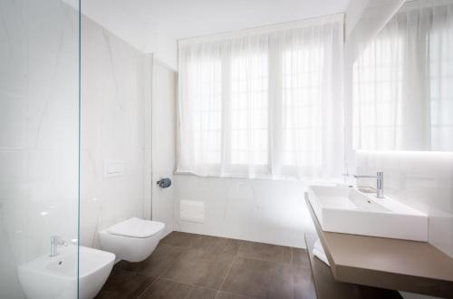 a white bathroom with a toilet and a sink at TURINHOMETOWN Residence Apartments in Turin