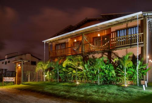 a house with a balcony at night at Pousada Vila dos Corais - Taipu de Fora in Marau