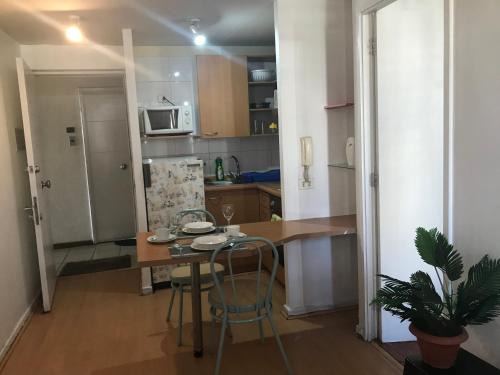 a kitchen with a table and a refrigerator at Apartment Relocation San Isidro in Santiago