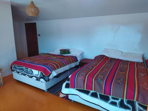 2 Betten nebeneinander in einem Zimmer in der Unterkunft Titicaca Kontiki Lodge Peru in Puno