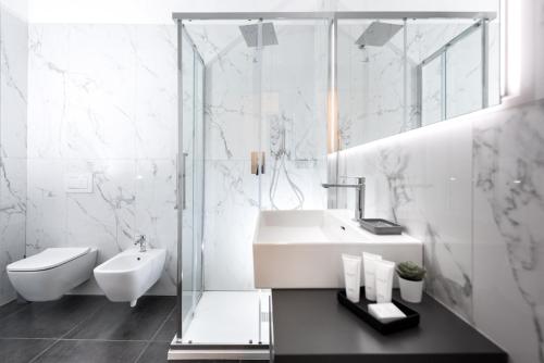 a white bathroom with a sink and a shower at TURINHOMETOWN Residence Apartments in Turin