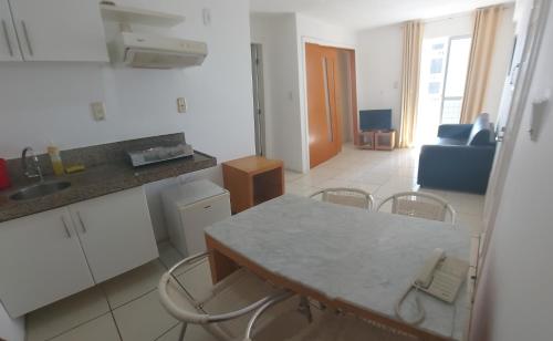 cocina y sala de estar con mesa y sillas en American Flat - Ponta D'areia - Ferreira Hospedagens, en São Luís