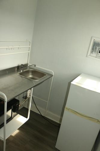una cocina con fregadero y refrigerador en Travel Inn Fort Pierce, en Fort Pierce