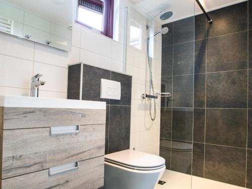 a bathroom with a shower and a toilet and a sink at Detached bungalow in Zeeland on the Stelleplas in Heinkensand