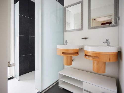 uma casa de banho com um lavatório e um espelho em Cozy holiday home with wellness located in Zeeland em heinkenszand