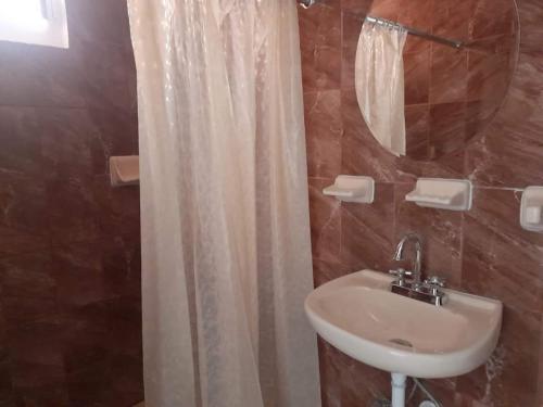 y baño con cortina de ducha y lavamanos. en Posada MemeLulu en Nanacamilpa