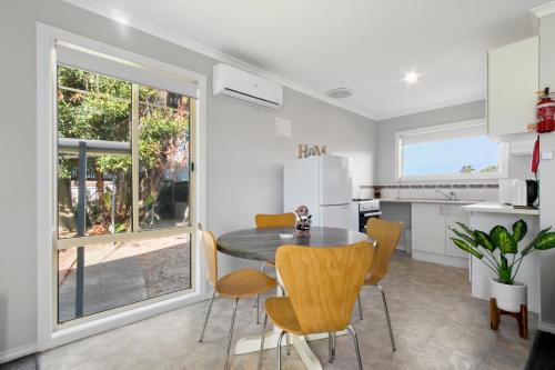 a kitchen and dining room with a table and chairs at The Beaches on Lakes - Big Family Holiday Home in Lakes Entrance