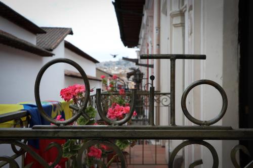 a balcony with pink flowers on a fence at Friends Hotel & Rooftop - Historic Center & Museums in Quito