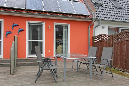 a table and chairs in front of a house with solar panels at Ferienhaus Pruchten FDZ 311 in Pruchten