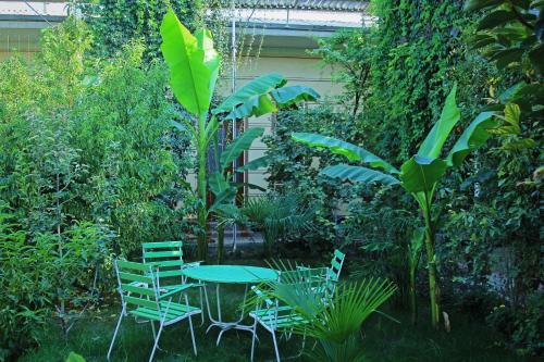 a table and chairs in a garden with plants at Evergreen Guesthouse in Margilan